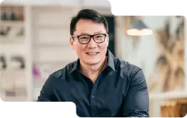 Smiling business professional in a smart navy shirt, with glasses, exuding expertise and approachability, reflective of the customer-focused service at our cryptocurrency exchange.