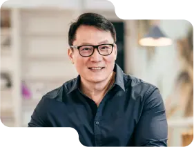 Smiling business professional in a smart navy shirt, with glasses, exuding expertise and approachability, reflective of the customer-focused service at our cryptocurrency exchange.