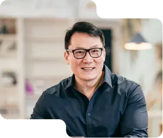 Smiling business professional in a smart navy shirt, with glasses, exuding expertise and approachability, reflective of the customer-focused service at our cryptocurrency exchange.