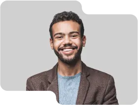 Enthusiastic young male team member with a friendly demeanor, wearing a brown blazer and light blue sweater, showcasing the dynamic and approachable team culture of our cryptocurrency exchange.